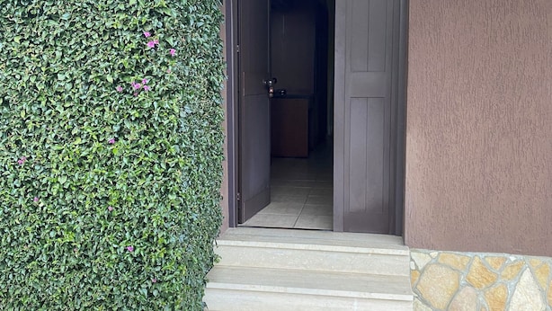 A building entrance with a stone-tiled pathway leading to a door. - American Motel (Cisterna di Latina)