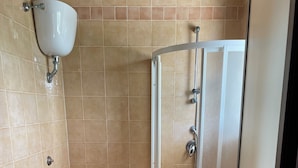 A bathroom with a toilet, bidet, and a glass-enclosed shower stall. - American Motel (Cisterna di Latina)