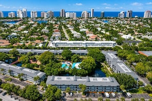 An aerial view of a resort area with multiple buildings, a central pool, and a marina. - Park Shore Resort, BLDG G #241*Great Views* (Park Shore Resort)