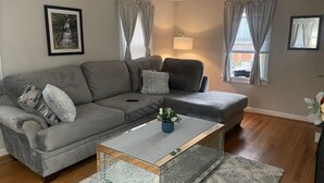 A living room with a grey sofa, a coffee table with a plant, and a lamp. - Home in Anderson Township (Cincinnati)
