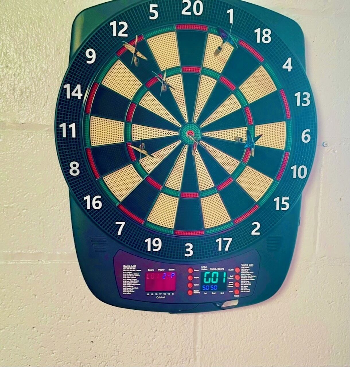 Een dartbord met een digitaal scorebord waarop de scores staan.