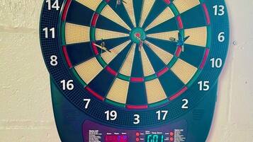 Een dartbord met een digitaal scorebord waarop de scores staan.