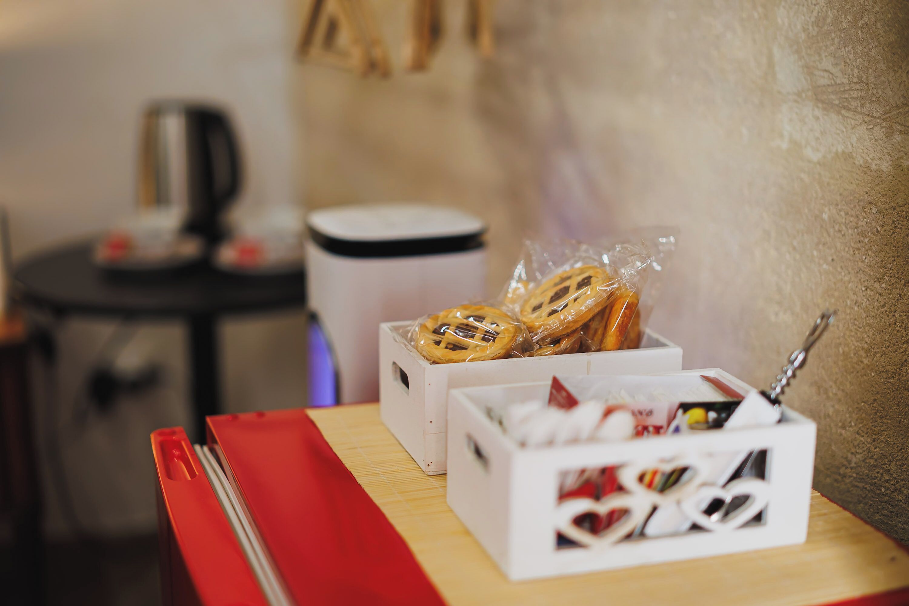 A table with a red napkin, a white box with a lid, and a white box with a lid containing various items.