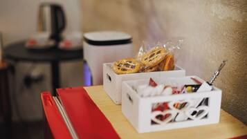 A table with a red napkin, a white box with a lid, and a white box with a lid containing various items.