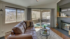 A living room with a leather sofa, a glass coffee table, and a fireplace. - Cozy La Veta Condo: Walk to Cuchara Mountain Park! (La Veta)