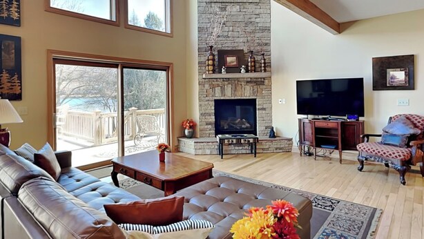 Una sala de estar con chimenea de piedra, un televisor grande y un sofá cómodo.
