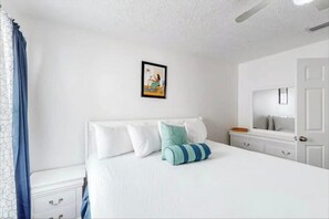 Cozy retreat with a large bed, bedside table, and framed picture.