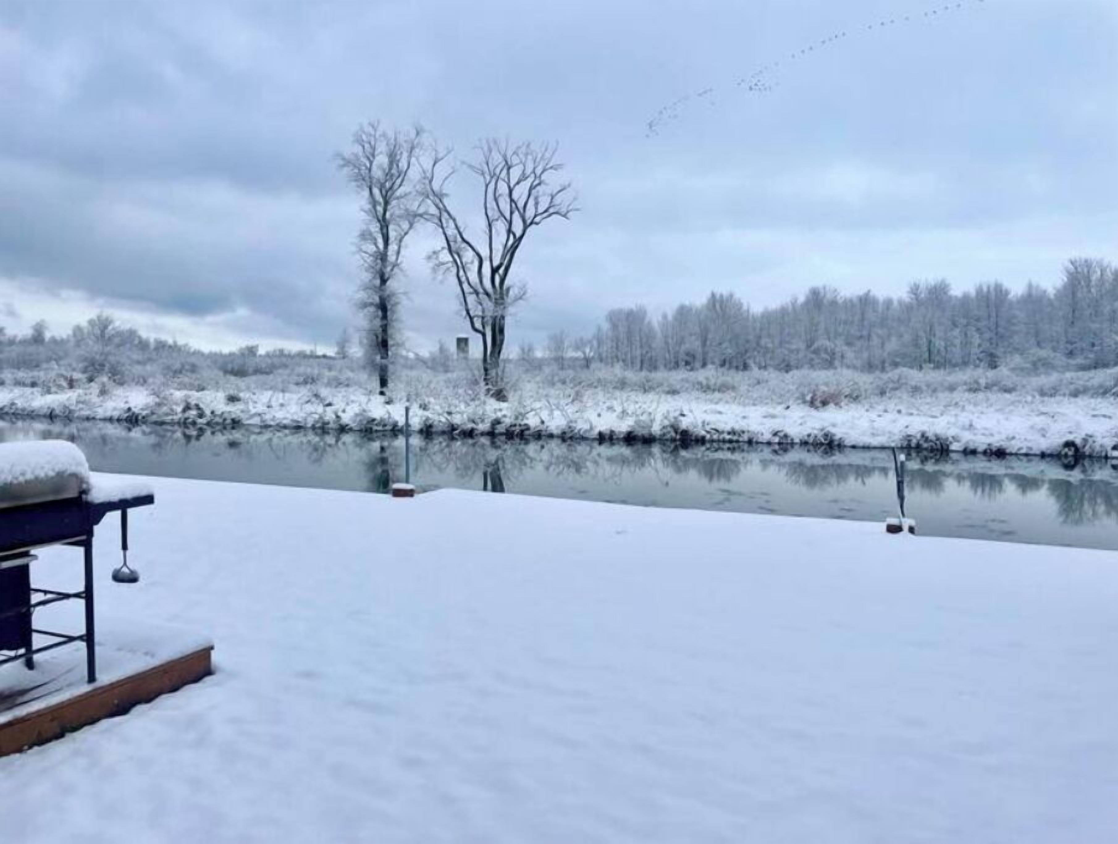 A snow-covered outdoor area with a bench and a fishing rod.