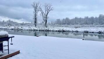 A snow-covered outdoor area with a bench and a fishing rod.