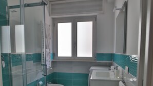 Ein Badezimmer mit Duschkabine, Toilette, Waschbecken und Badewanne.