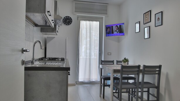 Eine moderne Küche mit Einbauherd, Spüle und Essbereich mit Tisch und Stühlen.