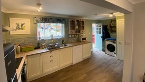 A compact kitchen with a sink, microwave, and wooden cabinets.
