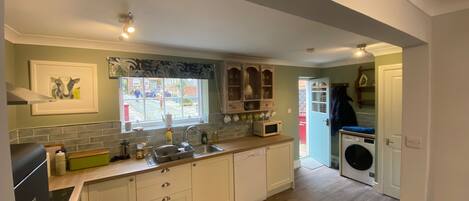 A compact kitchen with a sink, microwave, and wooden cabinets.