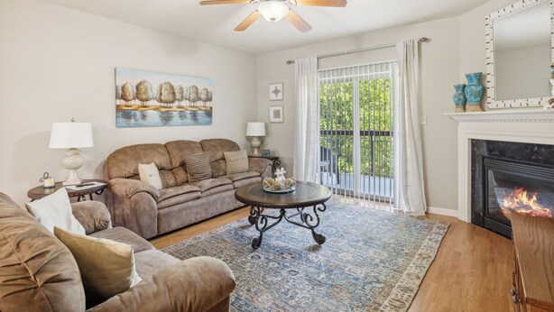 A living room with a sofa, armchairs, a coffee table, a fireplace, and a painting on the wall. - 2 Bedroom Condo with River View | Located in Pigeon Forge | Sleeps 6 (Pigeon Forge)