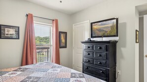 A bedroom with a bed, dresser, and a television on a stand. - 2 Bedroom Condo with River View | Located in Pigeon Forge | Sleeps 6 (Pigeon Forge)