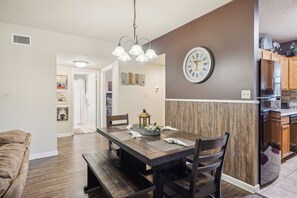 A modern kitchen with a built-in refrigerator, wooden cabinetry, and a dining area with a dark wooden table and benches. - Two bedroom, two bathroom with walk in Shower condo located just off the parkway (Pigeon Forge)