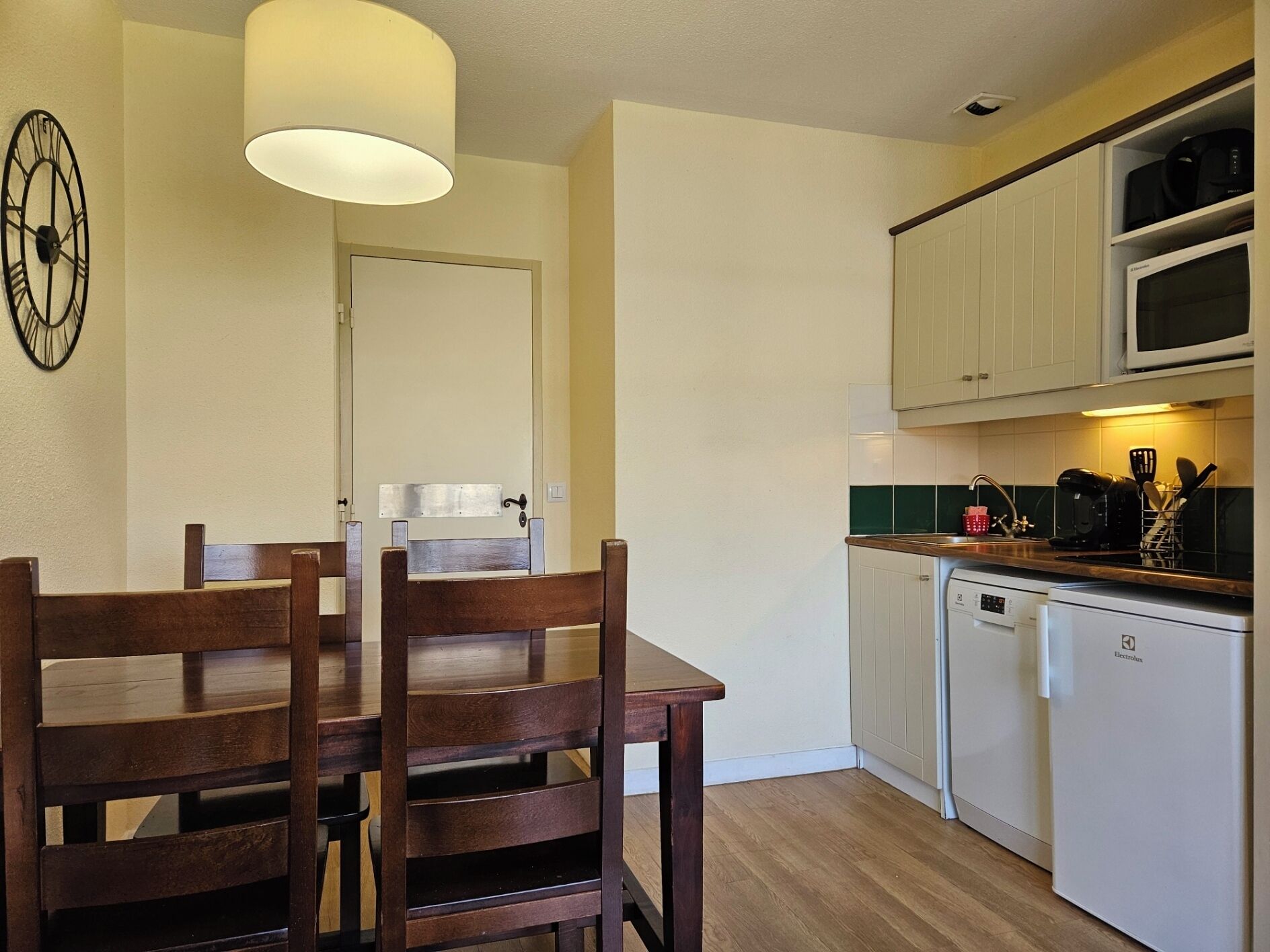 A compact kitchen with white cabinets, a built-in microwave, and a coffee maker.