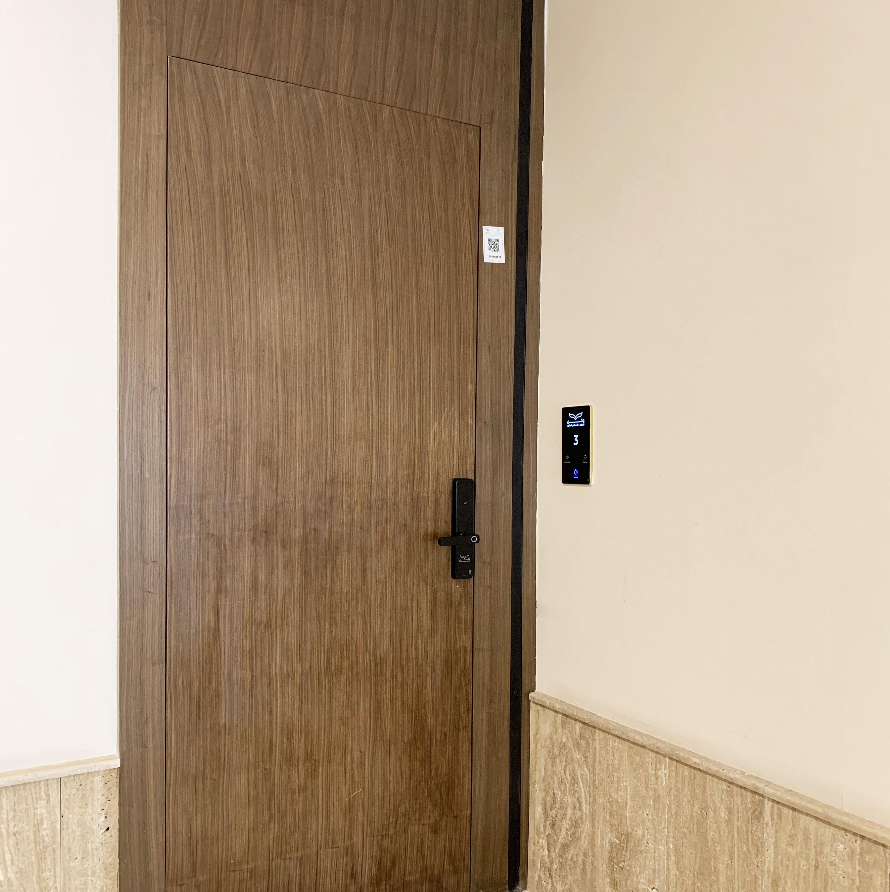 A wooden door with a black handle and a small sign above it.