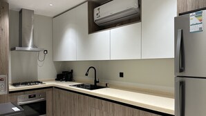 A modern kitchen with stainless steel appliances, a built-in oven, a gas stove, and a double sink.