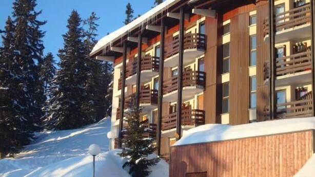 A multi-story hotel with balconies, surrounded by snow-covered trees and a ski slope. - 200m from ski slopes, 1st floor, balcony, tv, ski locker, 26m², La Rosière (La Rosière Montvalezan)