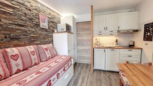 A compact living space with a sofa, kitchenette, and wooden flooring. - 200m from ski slopes, 1st floor, balcony, tv, ski locker, 26m², La Rosière (La Rosière Montvalezan)