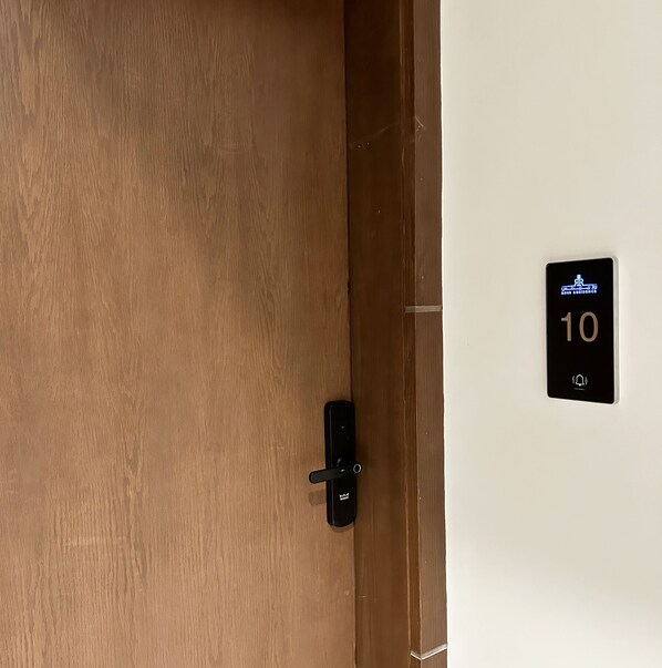 A wooden door with a black handle and a wall-mounted sign indicating room number 10. - Kease Malqa 31-10 Luxury Gold  AG23 (Riyadh)
