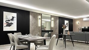 A modern dining area with a marble table, white chairs, and a grey sofa. - Kease Malqa 31-10 Luxury Gold  AG23 (Riyadh)