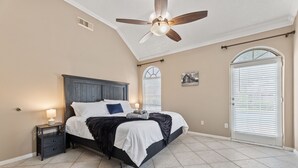 A bedroom with a bed, nightstand, ceiling fan, and a window with blinds. - Amazing Bay Villa Near NASA with Pool & Pool Table (Houston)