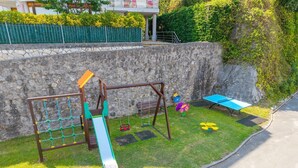 Ein Spielplatz mit Schaukel, Rutsche und Klettergerüst.