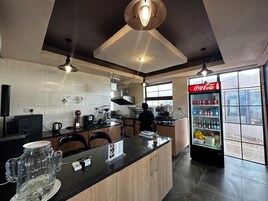 Una cocina moderna con una isla central, un refrigerador lleno de bebidas y un ventanal con vistas al exterior.