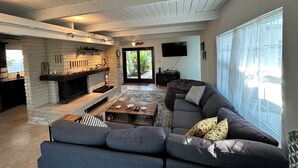 A spacious living room with a fireplace, a large sofa, and a television. - 3 BR Canal Home in Big Pine Key, FL - Private Pool/Spa - Great Boating Access!!! (Big Pine Key)