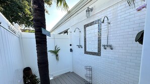 A white-tiled bathroom with a shower, a small window, and a metal rack. - 3 BR Canal Home in Big Pine Key, FL - Private Pool/Spa - Great Boating Access!!! (Big Pine Key)