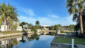 A calm water body with a bridge, palm trees, and buildings in the background. - 3 BR Canal Home in Big Pine Key, FL - Private Pool/Spa - Great Boating Access!!! (Big Pine Key)