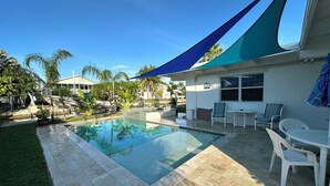 A backyard with a swimming pool, patio furniture, and a covered seating area. - 3 BR Canal Home in Big Pine Key, FL - Private Pool/Spa - Great Boating Access!!! (Big Pine Key)
