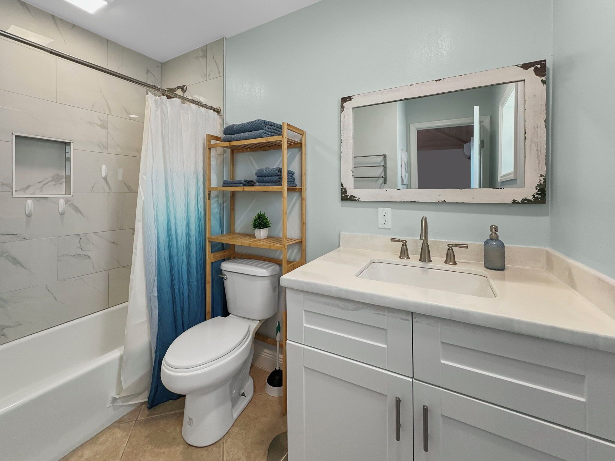 Een moderne badkamer met toilet, douche, wastafel en spiegel.
