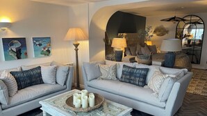 Un salon avec deux canapés, une table basse et des lampes décoratives.