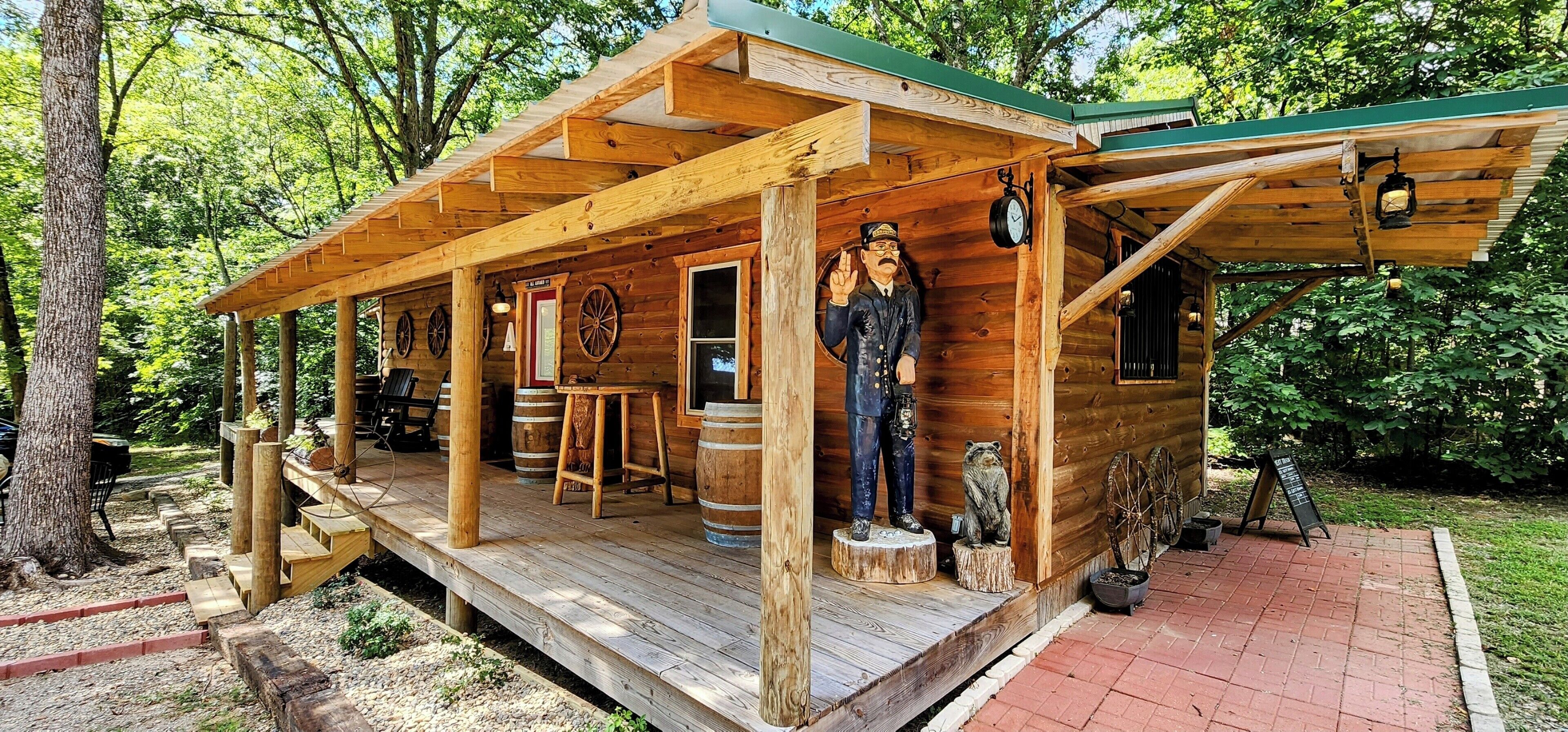 Eine rustikale Holzhütte mit Veranda, einer Statue und einer Uhr.