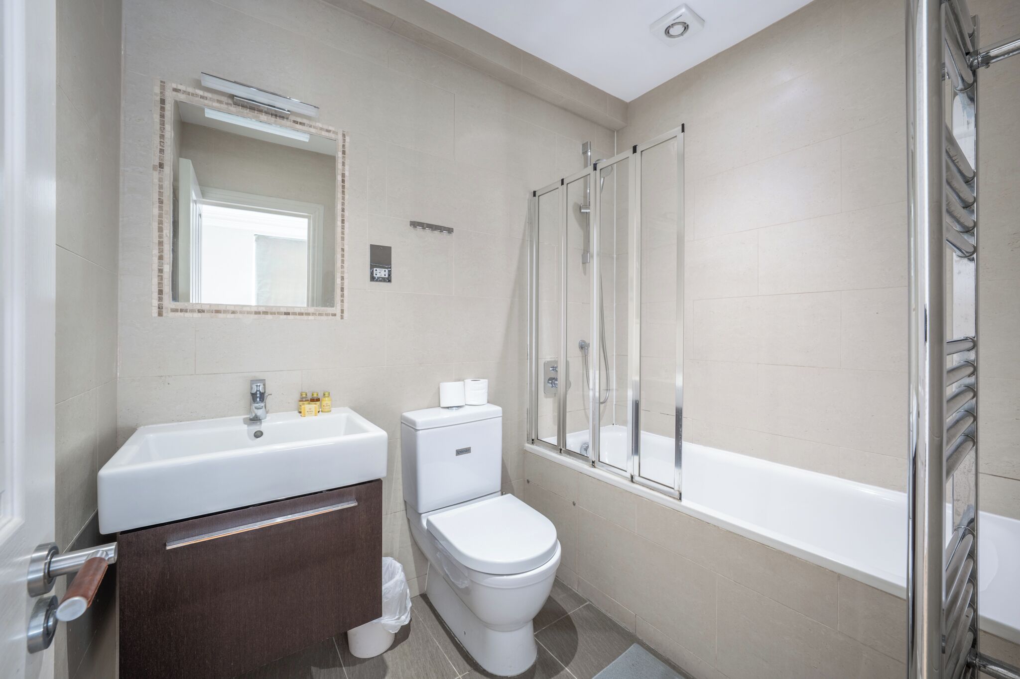 Une salle de bain équipée d’un lavabo, de toilettes et d’une douche à parois en verre.