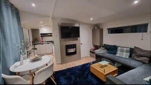 Un espacio habitable compacto con comedor, sofá y televisor.