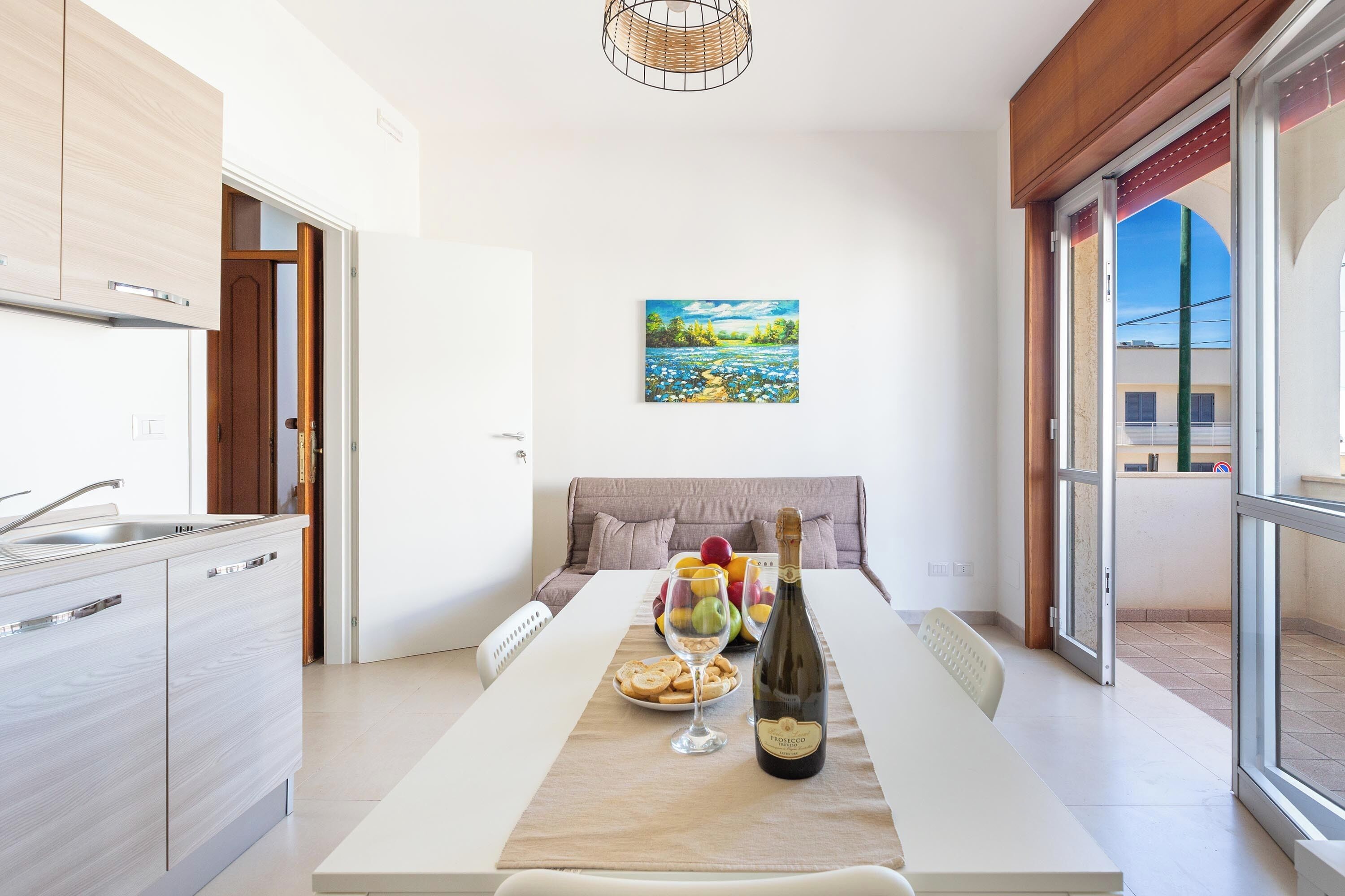Una cocina moderna con comedor, un cuadro en la pared y vistas al exterior.