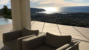A modern outdoor seating area with a view of the sea and a cityscape. - Villa met Zeezicht, Wifi en Airconditioning (Moraira)