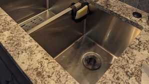 Een keuken met een roestvrijstalen spoelbak, een keukenrolhouder en een decoratieve kraan.