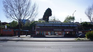 Restaurante de culinária tailandesa fechado, com um edifício de dois andares e estacionamento em frente.