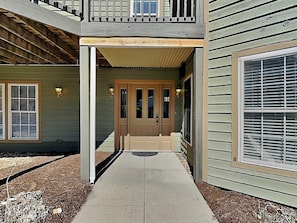 A two-story building with a covered entryway, a front door, and a visible mailbox. - Ski Boots N' Bathing Suits by Taylor Made Deep Creek (McHenry)