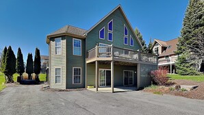 A two-story house with a balcony, a driveway, and a lawn. - Ski Boots N' Bathing Suits by Taylor Made Deep Creek (McHenry)