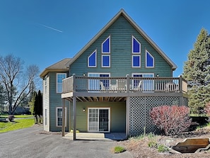 A two-story house with a balcony, a front door, and a garage. - Ski Boots N' Bathing Suits by Taylor Made Deep Creek (McHenry)