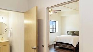 Un dormitorio con cama, ventilador de techo y ventana.