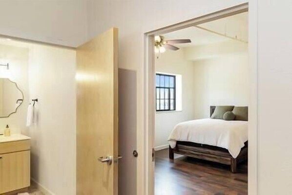 A bedroom with a bed, a ceiling fan, and a window. - Brand New SPACIOUS 2 BR Downtown Burlington! Unit 302N (Burlington)