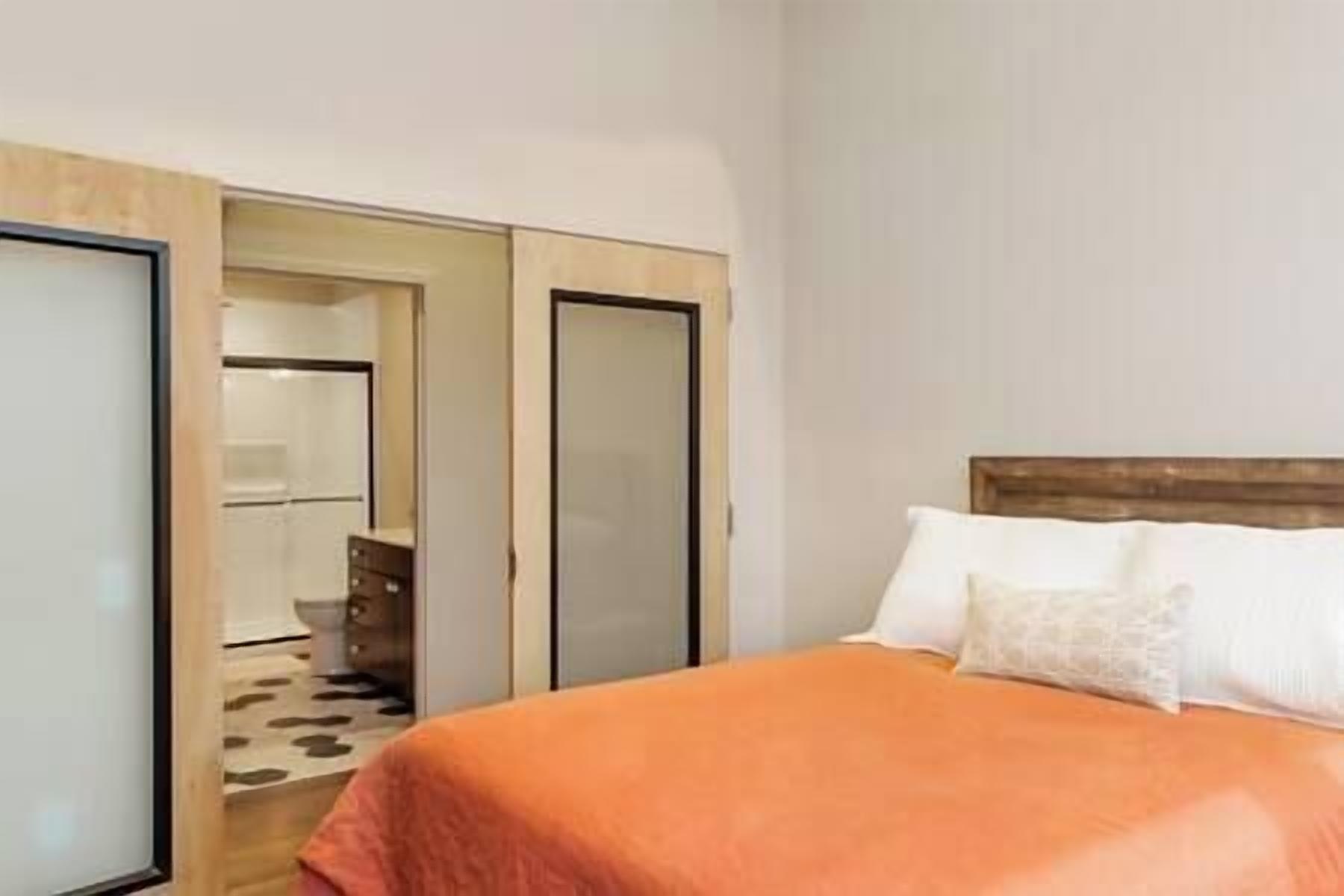 A bedroom with a bed, a wardrobe, and a mirror.