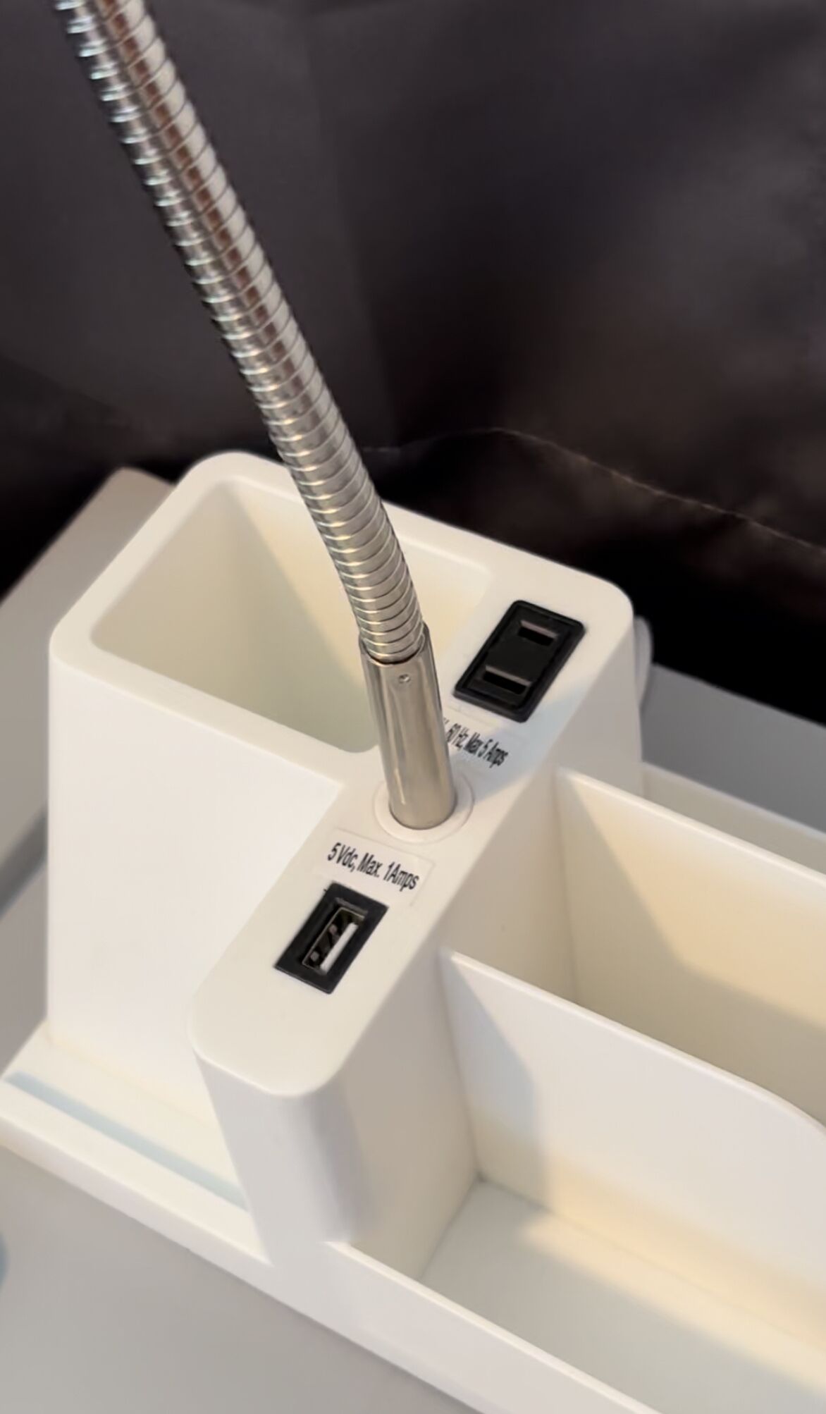 Une prise électrique blanche avec une fiche métallique et un interrupteur.